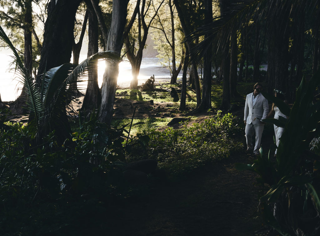Bridal couple walking together through forest