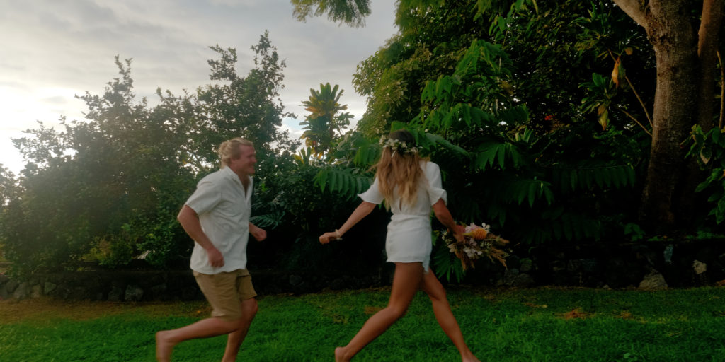 Newly weds running toward Hawaiian treehouse